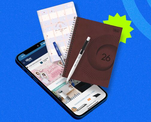 Celular, cadernos e caneta sobre fundo azul