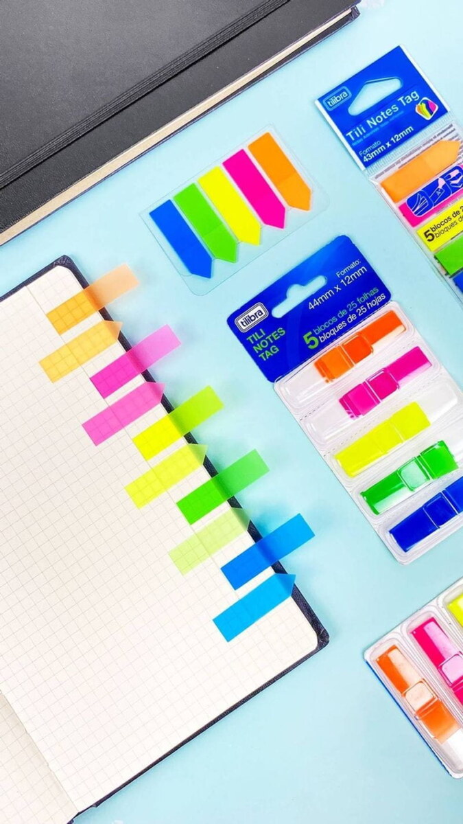 Marcadores de página adesivos TiliNotes Coloridos colados em caderno pontilhado e dispostos na mesa
