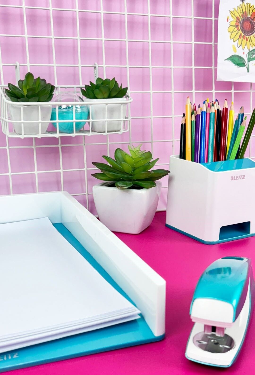 Mesa de escritório colorida com plantas e materiais de papelaria