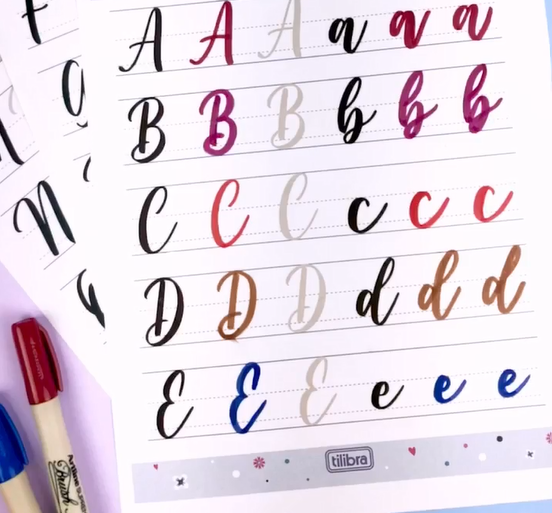 Folha de papel pautado com alfabeto colorido em caligrafia