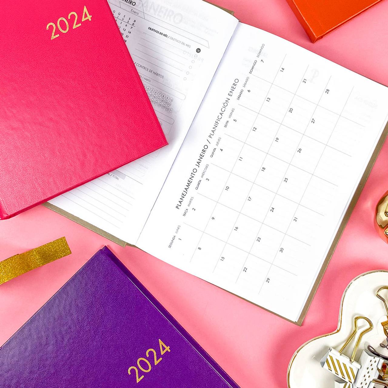 Agendas dispostas em fundo rosa com visão de planejamento mensal 