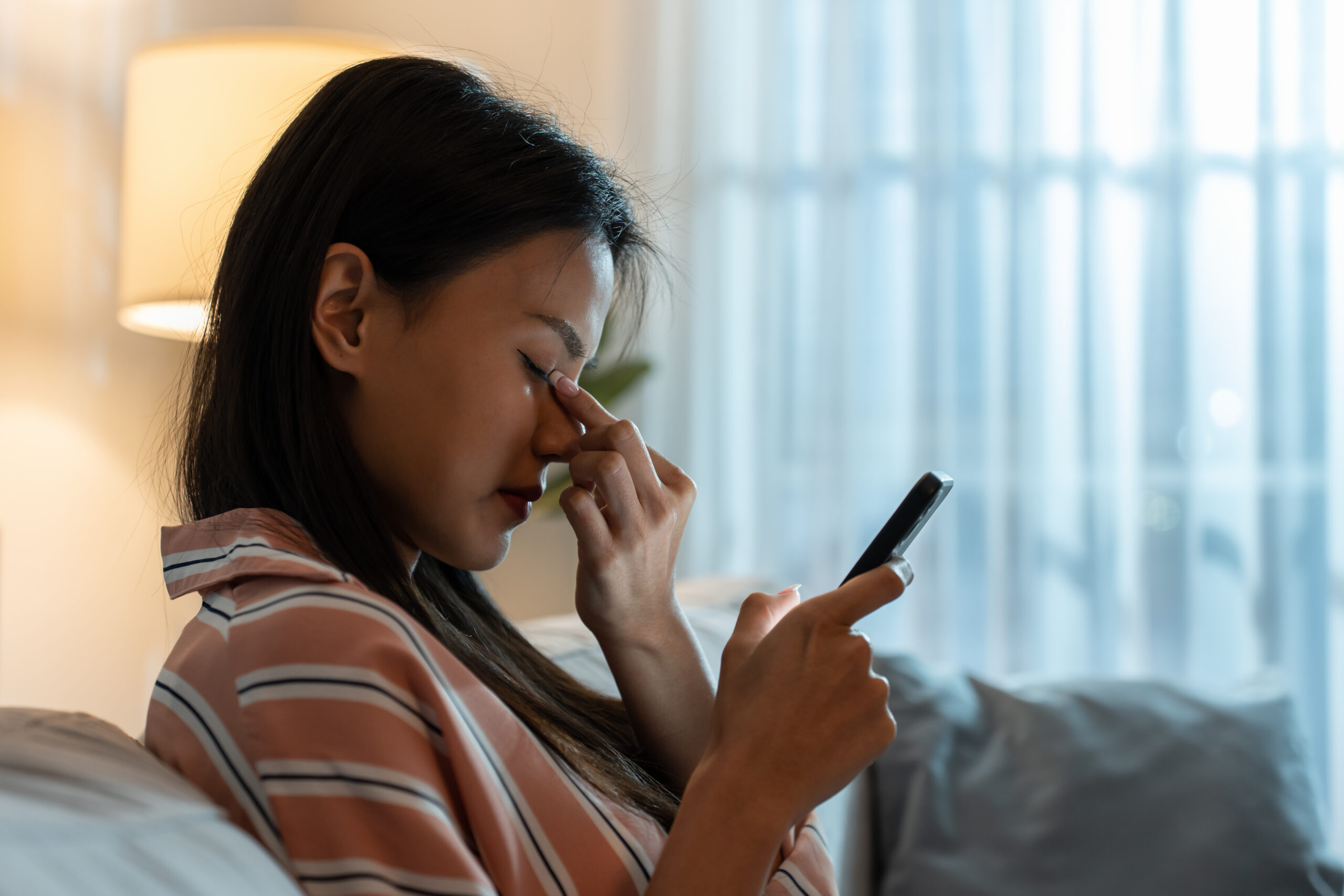 Mulher com dedos no canto dos olhos enquanto os fecha para descansar a vista