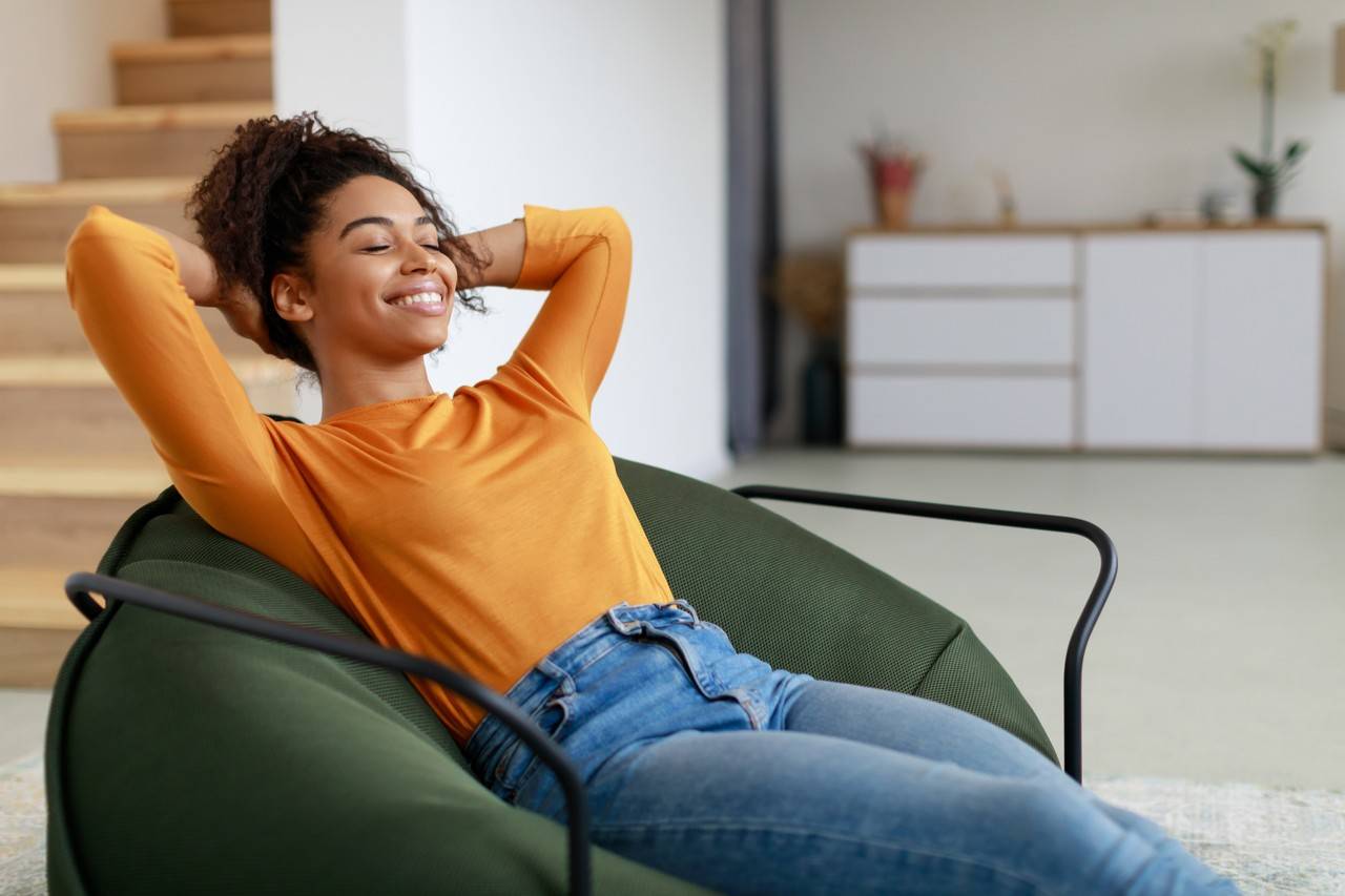 Mulher sentada em poltrona fofa de forma confortável e relaxada