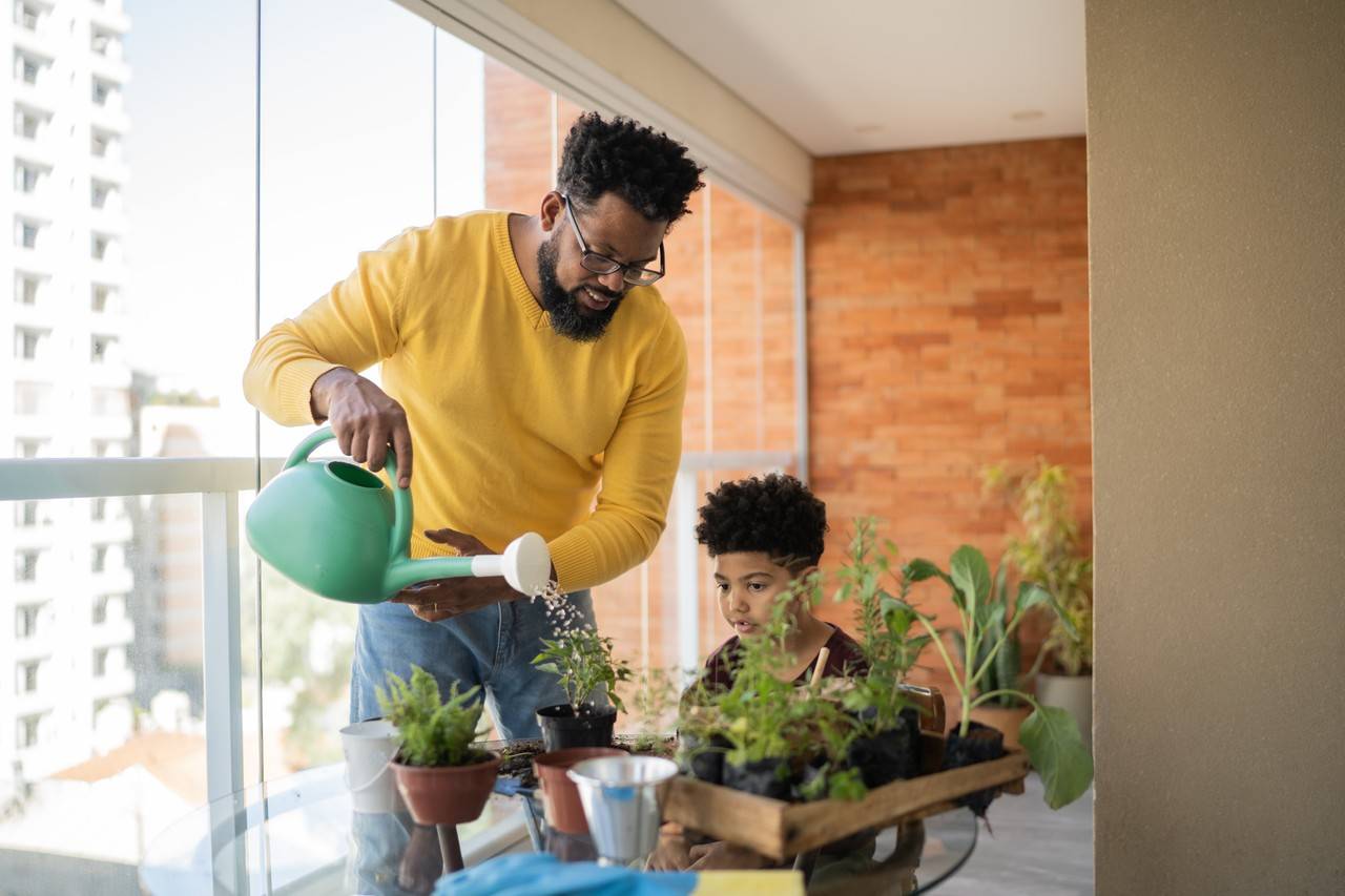 Pai e filho colocando agua nas plantas