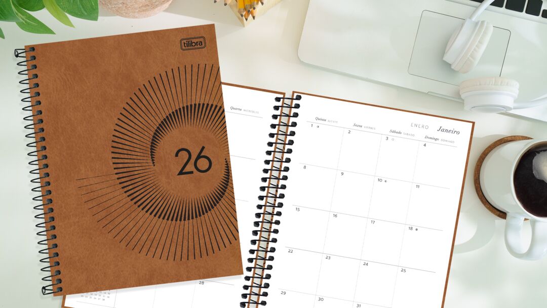 Caderno e calendário sobre mesa de trabalho