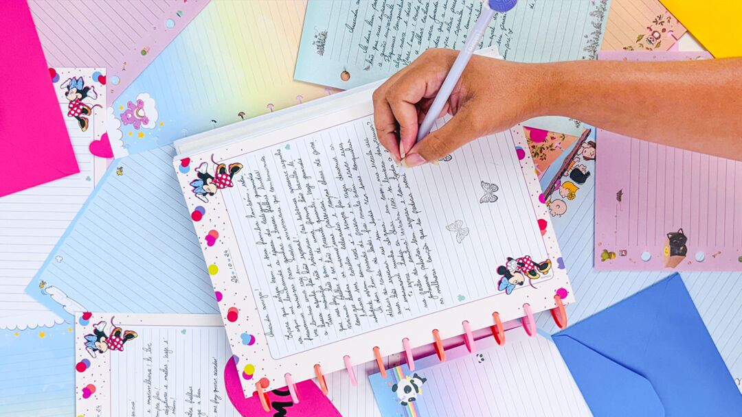 Caderno colorido com escrita e material de papelaria ao redor