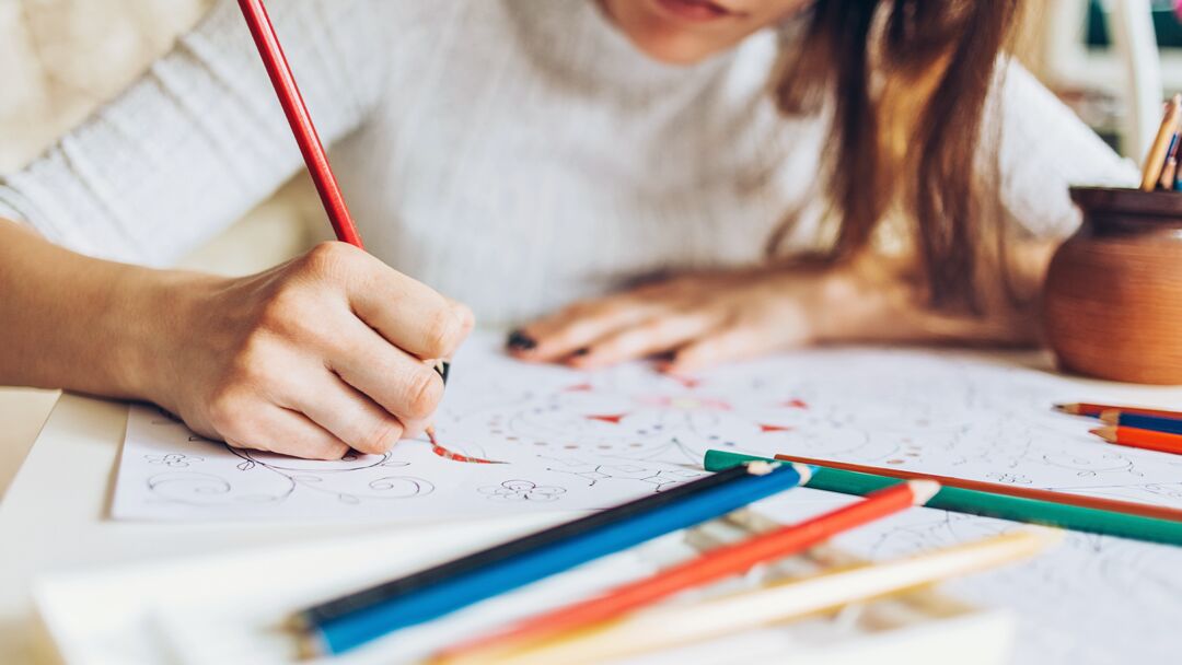 pessoa colorindo com lápis em papel