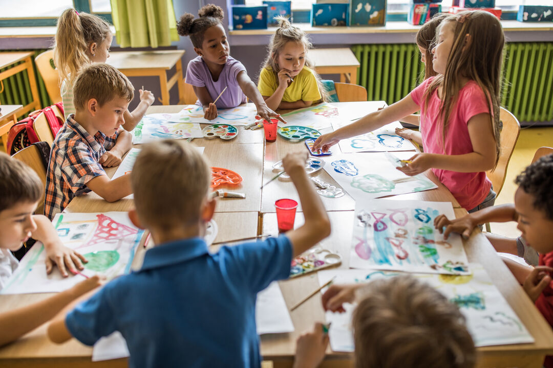 Crianças pintando em atividade escolar de arte