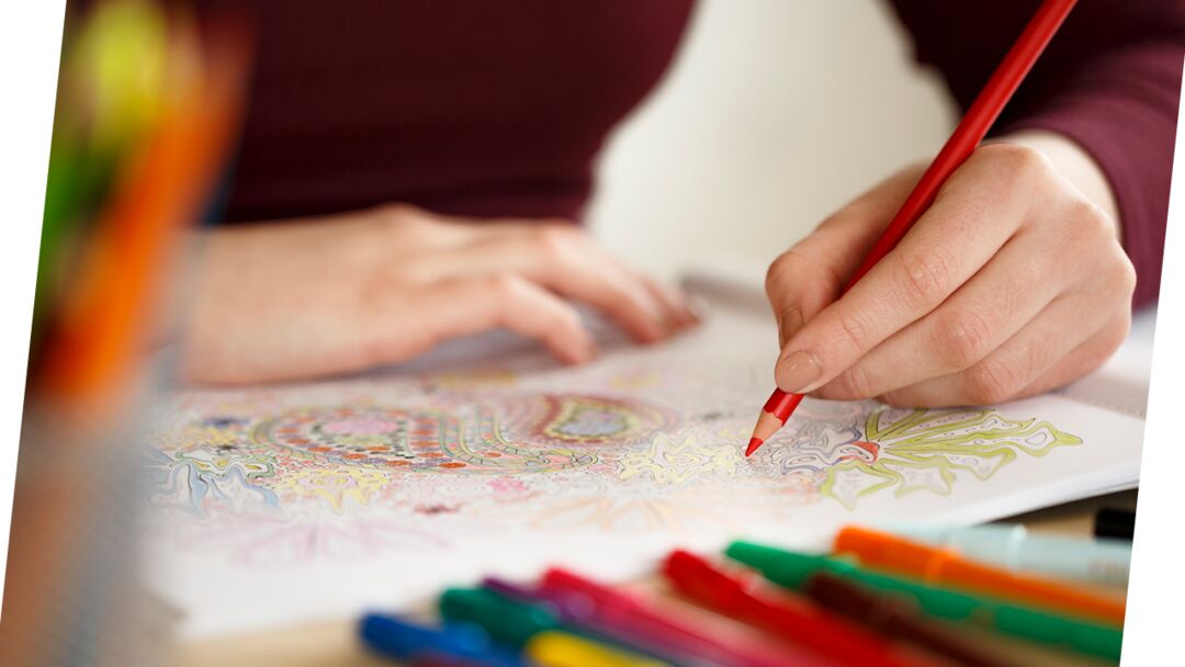 Pessoa colorindo um desenho relaxante com lápis.