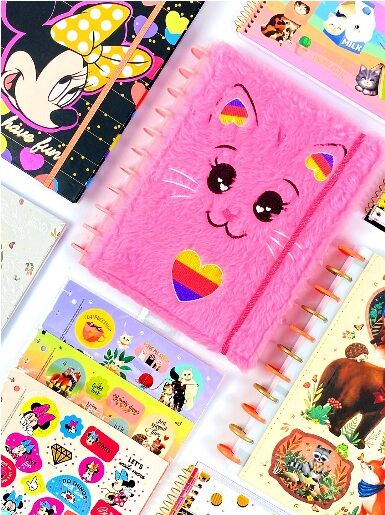 Cadernos coloridos e adesivos divertidos em mesa