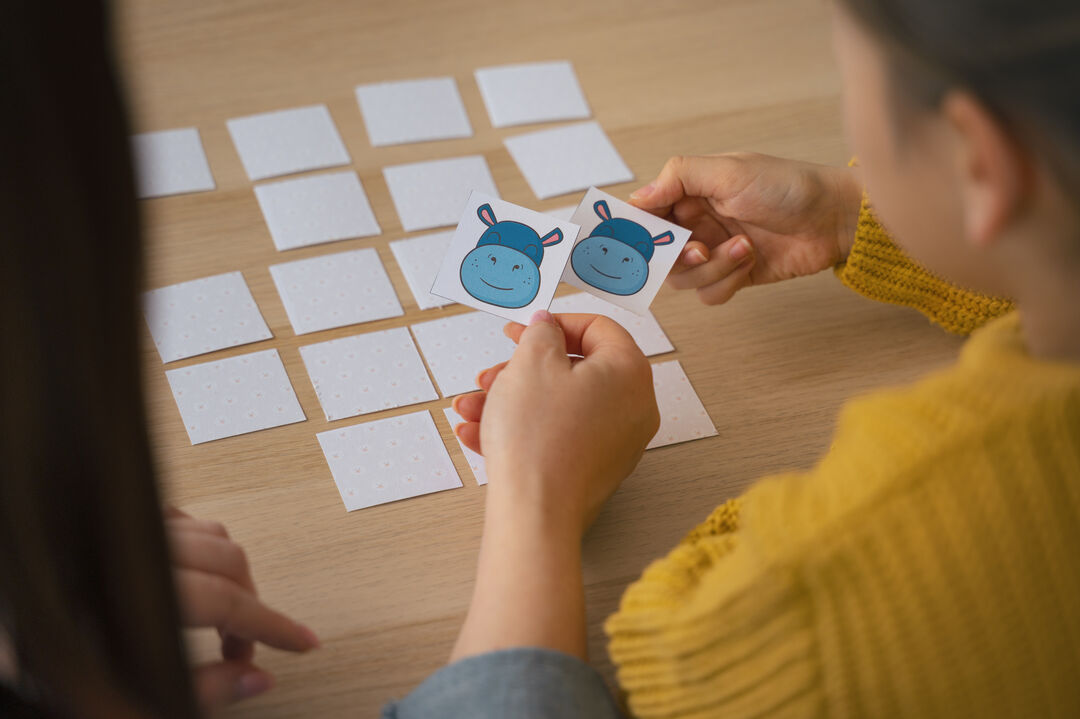 Crianças jogando jogo de memória com cartas divertidas.