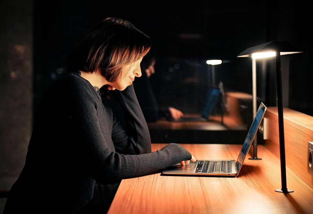 Mulher trabalhando em laptop à noite