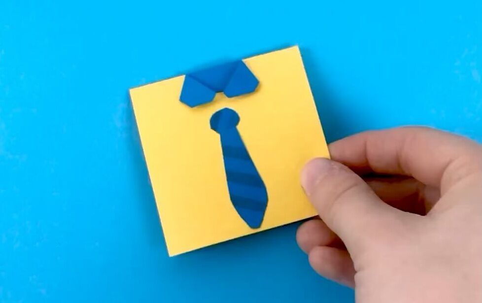 Papel amarelo com gravata azul em forma de origami