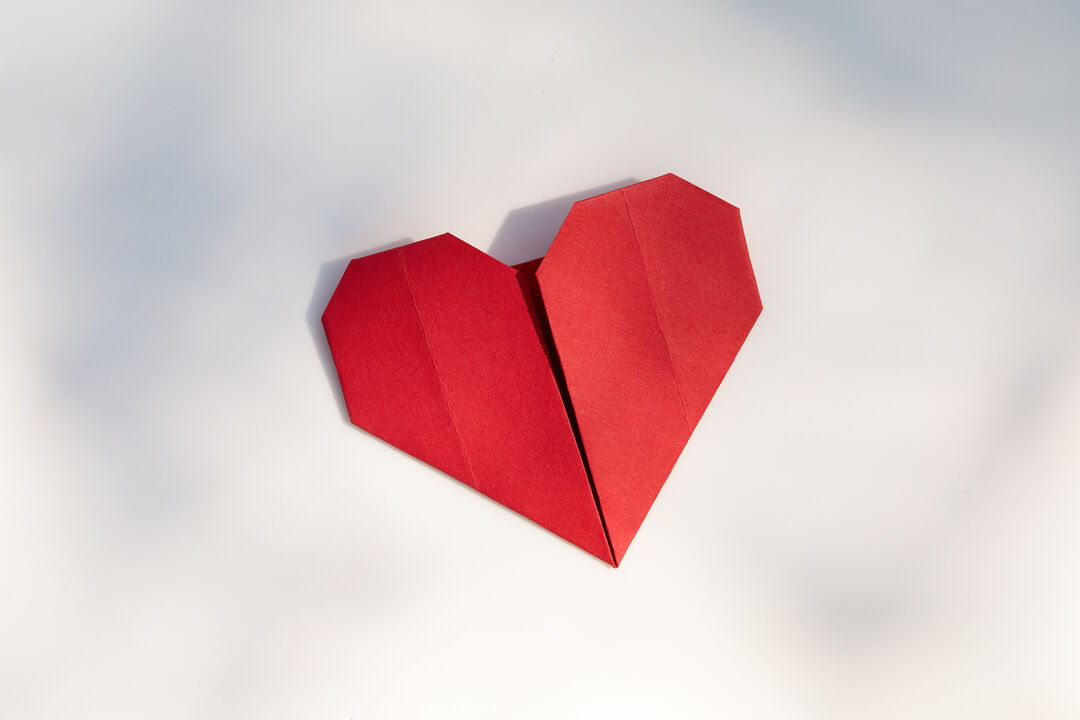 Coração de origami vermelho sobre fundo claro